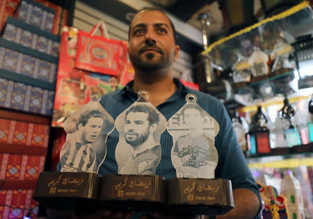 Mohamed Gamal works on lanterns with portraits of Egyptian professional football players; Stoke City's Ramadan Sobhi (L), AC Roma's Mohamed Salah (C), and FC Basel's Omar Gaber, in Cairo, Egypt May 16, 2017. REUTERS/Mohamed Abd El Ghany