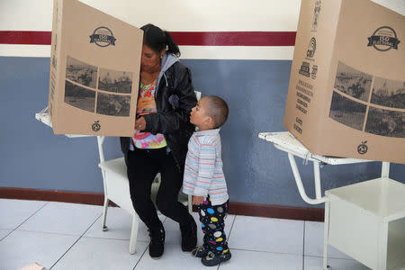 A woman casts her vote in a school used as a polling station during the presidential election, in Quito, Ecuador April 2, 2017. REUTERS/Mariana Bazo