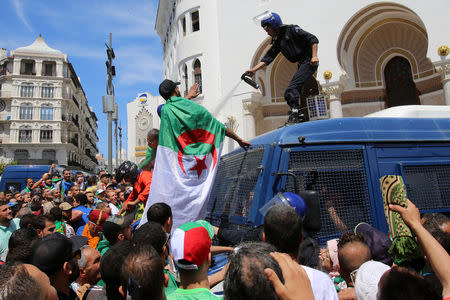 A police officer sprays tear gas at anti-government protesters in Algiers, Algeria May 17, 2019. REUTERS/Ramzi Boudina