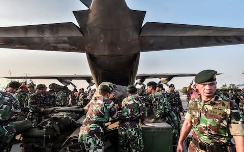 Indonesian soldiers load emergency supplies into a Hercules military plane before heading to Palu at Halim Perdanakusuma military base in Jakarta - Credit: Reuters