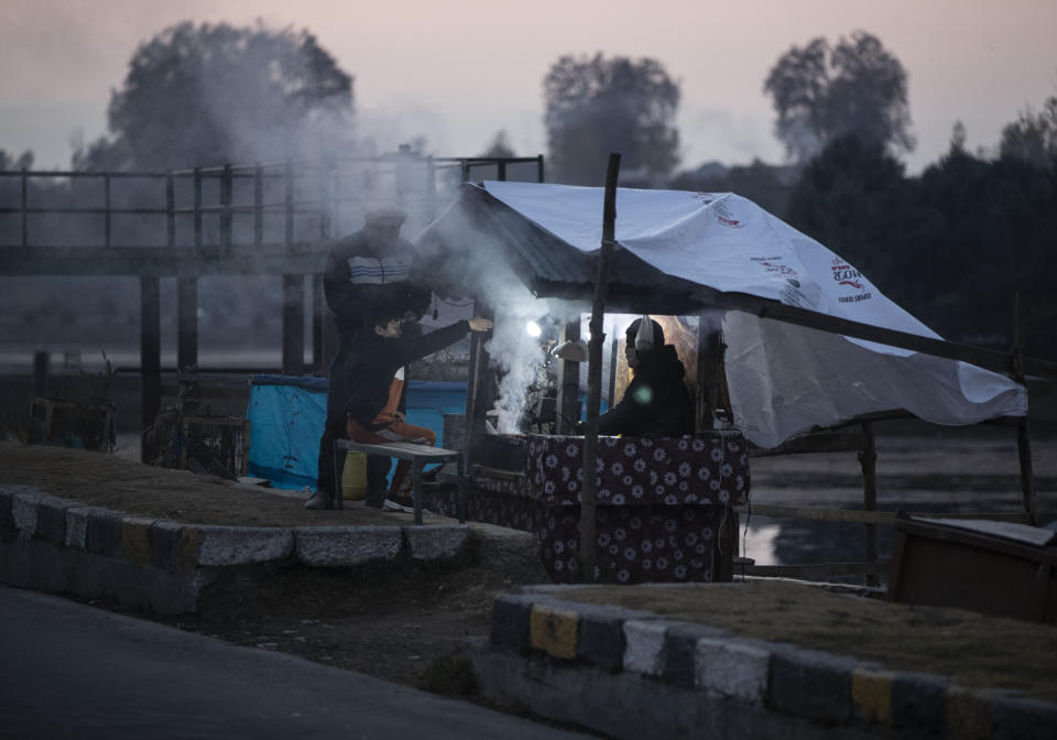 A Kashmiri vendor prepares traditional barbeque mutton for customers on the bank of the Dal Lake on a cold evening in Srinagar on Nov. 16, 2020. (AP Photo/Mukhtar Khan)