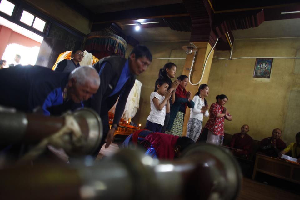 Family members of Nepalese mountaineer Ang Kaji Sherpa, killed in an avalanche on Mount Everest, offer prayers at the Sherpa Monastery in Katmandu, Nepal, Sunday, April 20, 2014. Rescuers were searching through piles of snow and ice on the slopes of Mount Everest on Saturday for four Sherpa guides who were buried by an avalanche that killed 12 other Nepalese guides in the deadliest disaster on the world's highest peak. The Sherpa people are one of the main ethnic groups in Nepal's alpine region, and many make their living as climbing guides on Everest and other Himalayan peaks. (AP Photo/Niranjan Shrestha)