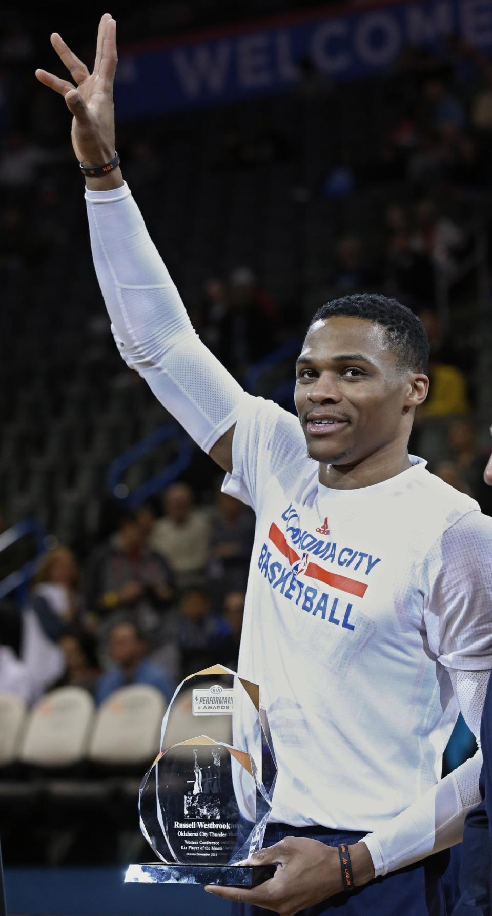 Oklahoma City Thunder guard Russell Westbrook waves to the crowd after accepting his Western Conference Kia Player of the month award for Oct./Nov. 2016, before an NBA basketball game against the Phoenix Suns in Oklahoma City, Saturday, Dec. 17, 2016. (AP Photo/Sue Ogrocki)