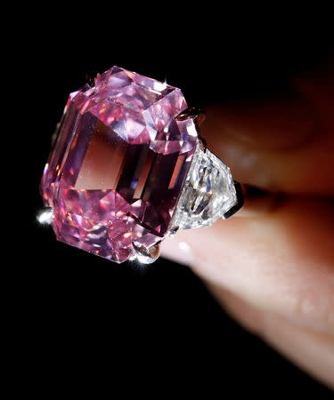 FILE PHOTO: A Christie's staff holds a 18.96 carat Fancy Vivid Pink Diamond during a preview in Geneva, November 8, 2018. REUTERS/Denis Balibouse/File Photo