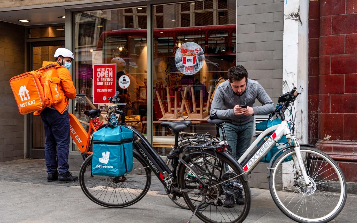 Food delivery couriers collect orders from a KFC restaurant