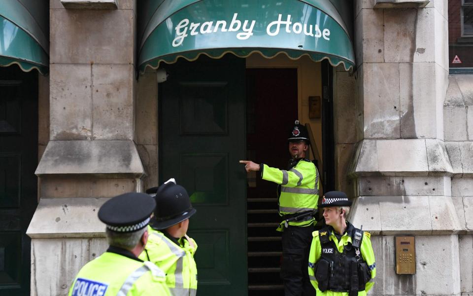 Police outside Granby House near Manchester Piccadilly station - Credit: CHRIS J RATCLIFFE/AFP