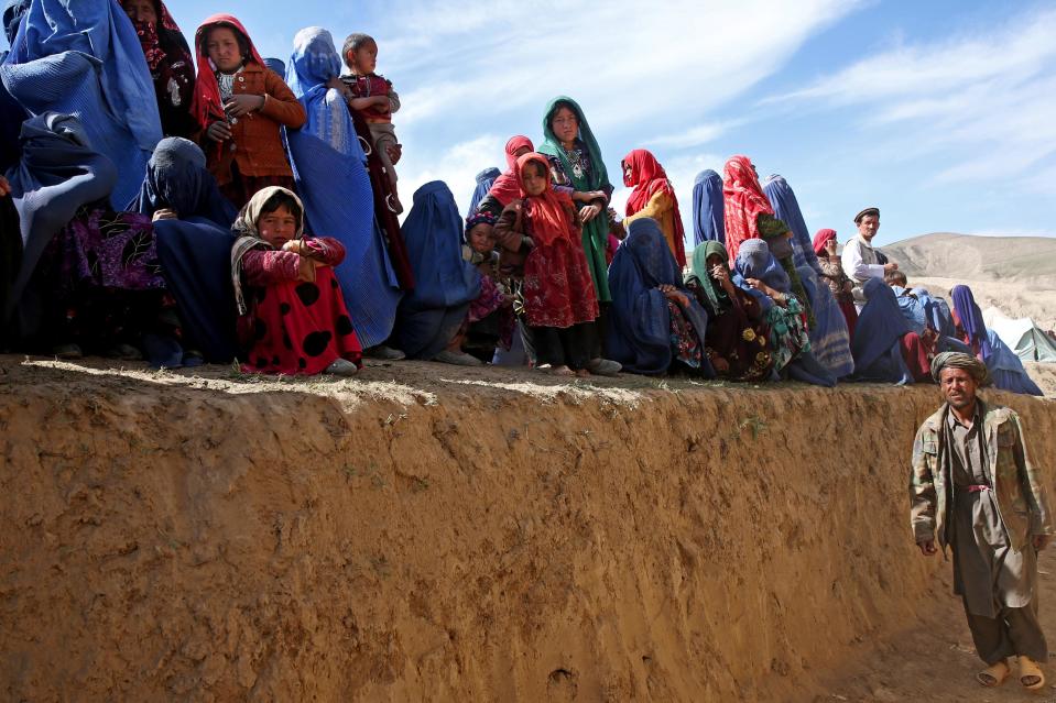 Survivors wait to receive food donations near the site of Friday's landslide that buried Abi-Barik village in Badakhshan province, northeastern Afghanistan, Tuesday, May 6, 2014. Authorities tried to help families displaced by the torrent of mud that swept through Abi-Barik village after hundreds were killed. (AP Photo/Massoud Hossaini)