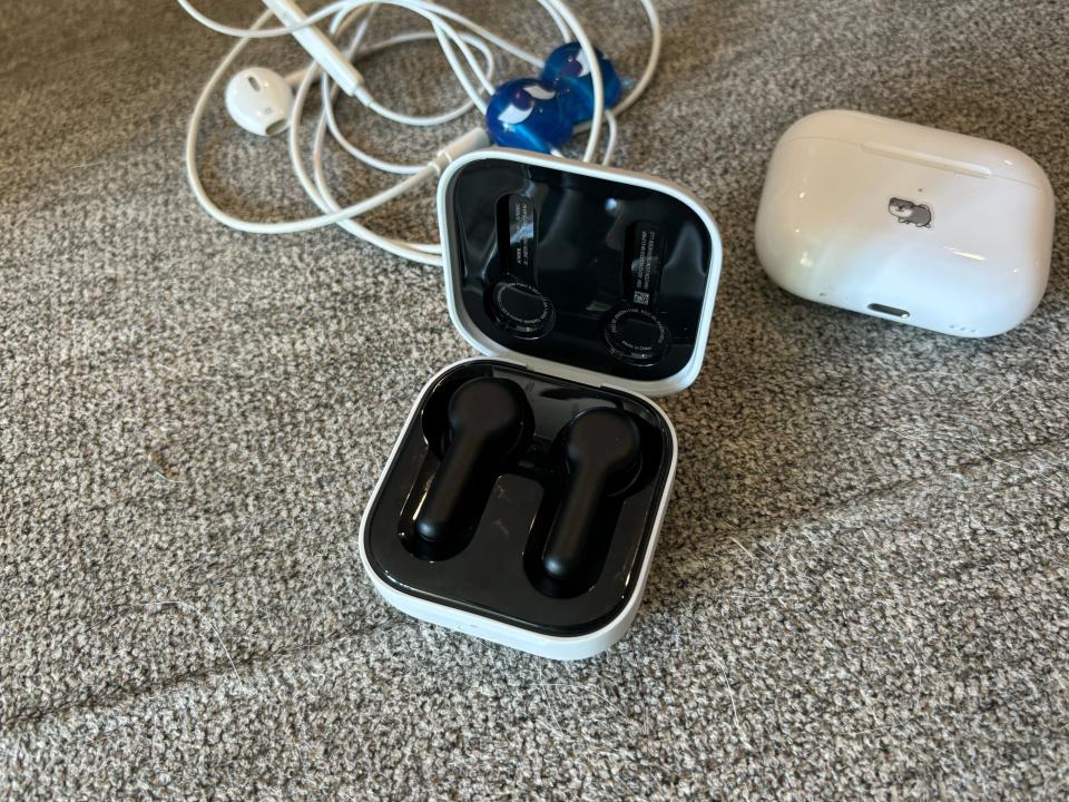 Amazon Echo Buds on a gray surface in front of earpods and AirPods Pro 2