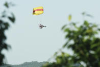 A worker in a powered parachute searches for a runaway leopard in Hangzhou in eastern China's Zhejiang province Sunday, May 9, 2021. A search for the last of three leopards that escaped from a safari park in eastern China was ongoing, authorities said Monday, May 10, 2021 as the park came under fire for concealing the breakout for nearly a week. (Chinatopix via AP)