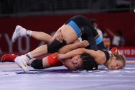 <p>Germany's Aline Rotter Focken (blue) wrestles China's Zhou Qian in their women's freestyle 76kg wrestling early round match during the Tokyo 2020 Olympic Games at the Makuhari Messe in Tokyo on August 1, 2021. (Photo by Jack GUEZ / AFP)</p> 