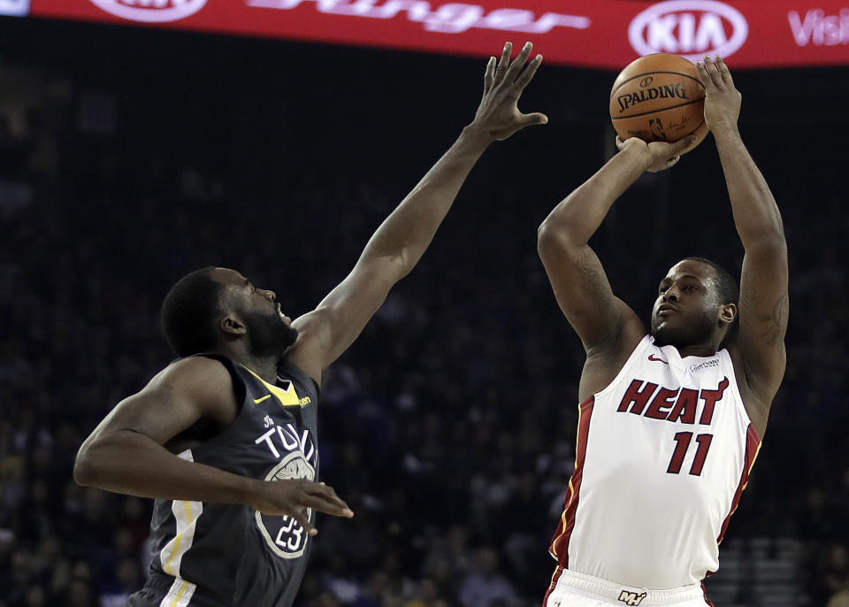 Miami Heat guard Dion Waiters, right, shoots against Golden State Warriors' Draymond Green, left, during the first half of an NBA basketball game, Sunday, Feb. 10, 2019, in Oakland, Calif. (AP Photo/Ben Margot)