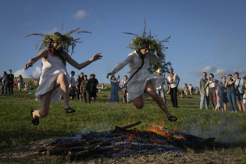 Ukrainian women jump over the fire at a traditional Midsummer Night celebration near capital Kyiv, Ukraine, Sunday, June 23, 2024. The age-old pagan festival is still celebrated in Ukraine amid the third year of Russia-Ukraine war. Many people believe that jumping over the fire will cleanse them of evil spirits.(AP Photo/Efrem Lukatsky)