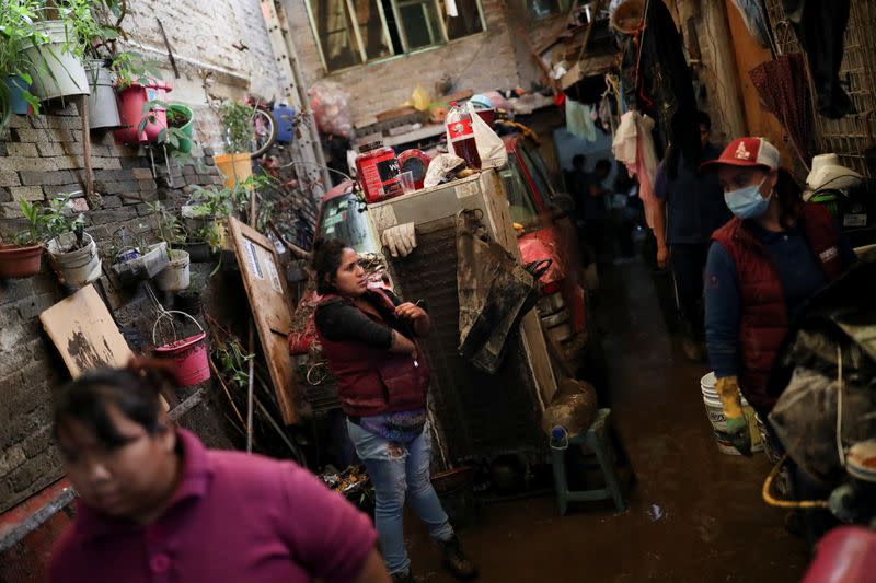 People clean up debris of the damage caused by heavy rainfall in the municipality of Ecatepec