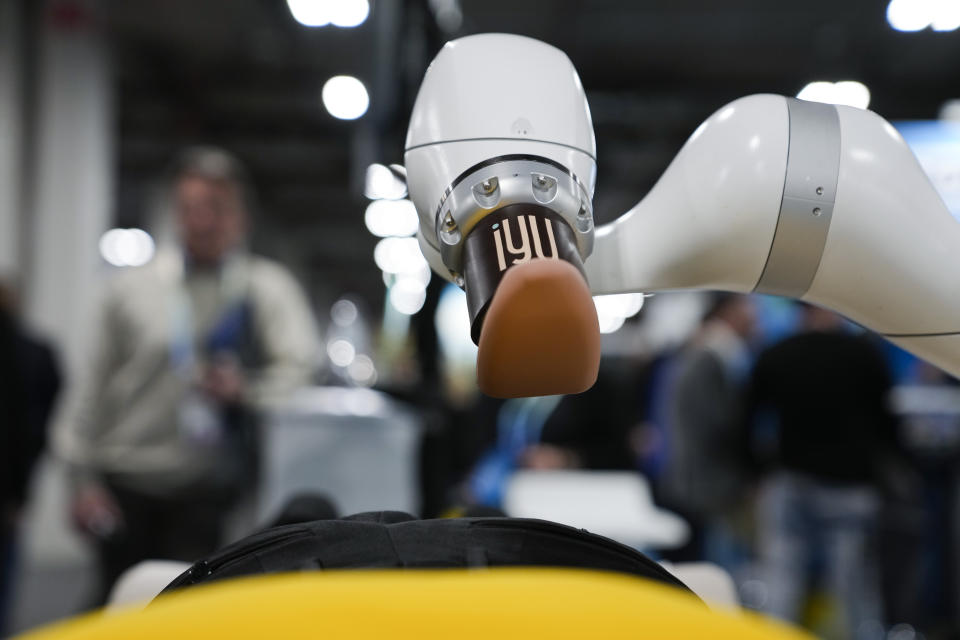 An attendee receives a massage from the iYU AI-assisted massage robot, by Capsix Robotics during the CES tech show Wednesday, Jan. 10, 2024, in Las Vegas. (AP Photo/Ryan Sun)