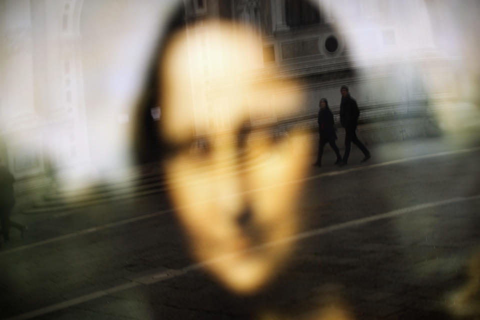 People walk past Leonardo da Vinci museum, temporary closed due to the COVID-19 virus outbreak, in Venice, Saturday, Feb. 29, 2020. A U.S. government advisory urging Americans to reconsider travel to Italy due to the spread of a new virus is the "final blow" to the nation's tourism industry, the head of Italy's hotel federation said Saturday. Venice, which was nearing recovery in the Carnival season following a tourist lull after record flooding in November, saw bookings drop immediately after regional officials canceled the final two days of celebrations this week, unprecedented in modern times. (AP Photo/Francisco Seco)