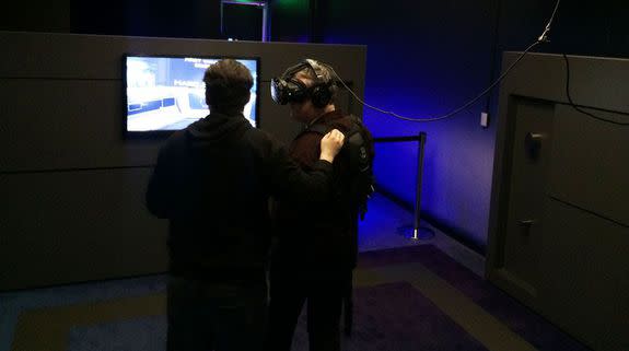 An IMAX VR employee sets up a new user in one of their VR "pods."