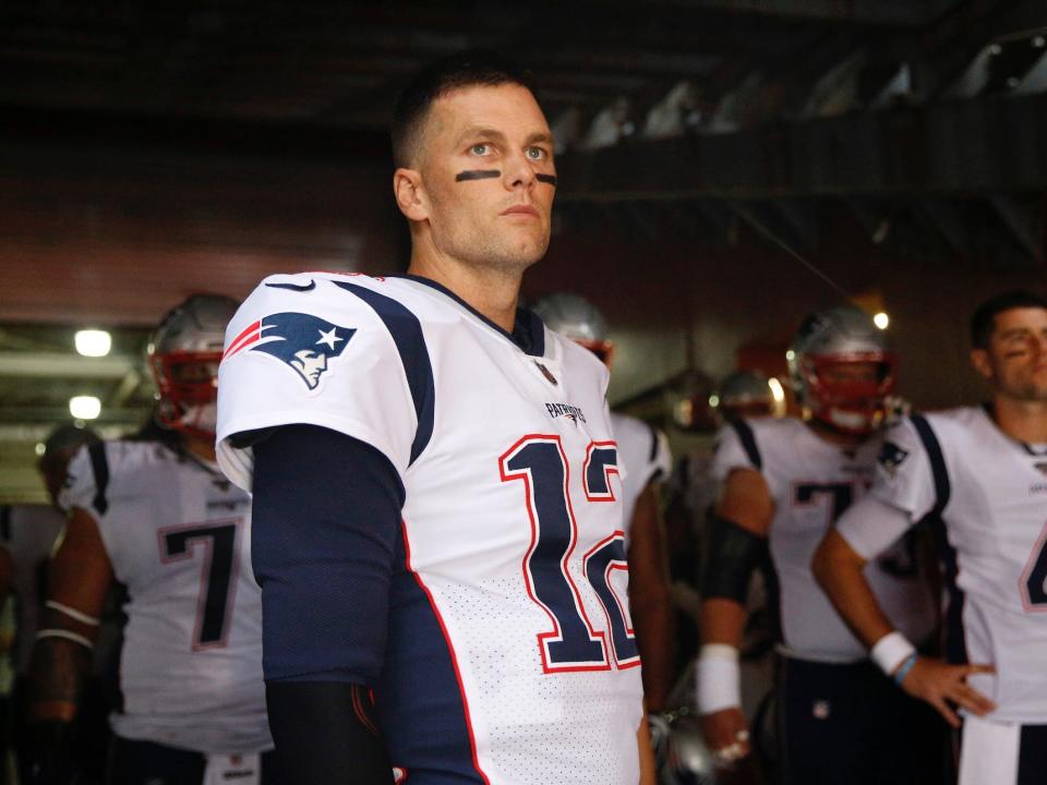 Tom Brady stands with Patriots players in the tunnel before a game in 2019.