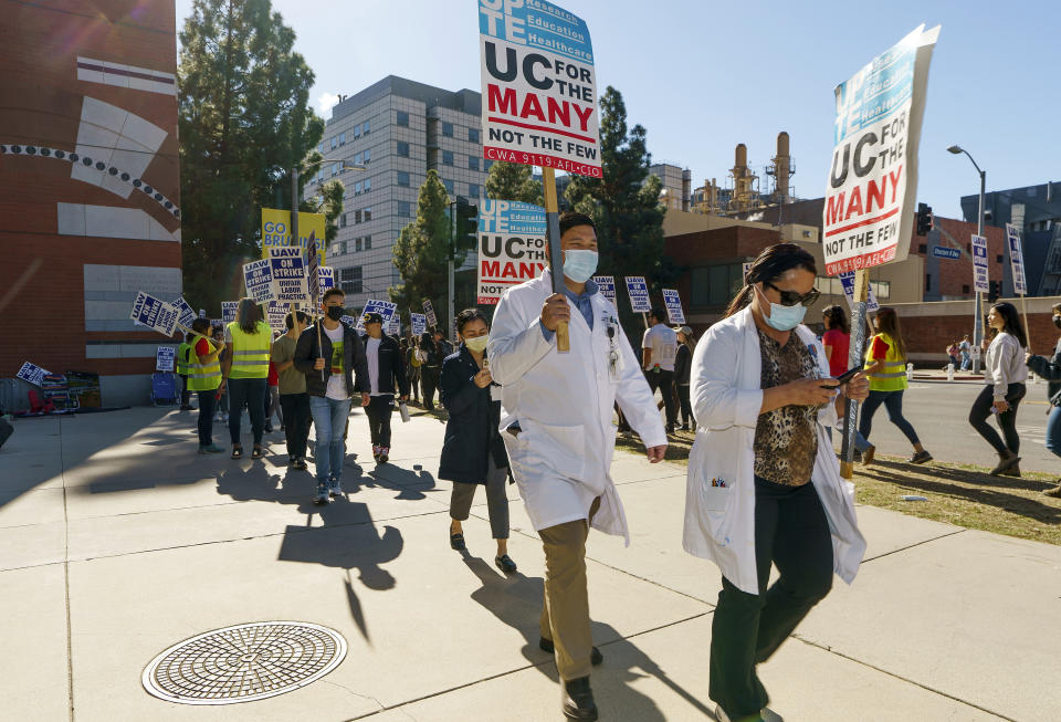 FILE - People participate in a protest outside the UCLA campus in Los Angeles, Monday, Nov. 14, 2022. Nearly 48,000 unionized academic workers at all 10 University of California campuses have walked off the job Monday. The University of California has reached an agreement with some 36,000 graduate student teaching assistants and other academic workers for increased pay and benefits that could potentially end the month-long strike at the prestigious state system. The strike disrupted classes at all 10 of the university system's campuses and was the largest strike of academic workers in the nation. The agreement still needs to be ratified before the strike officially ends. (AP Photo/Damian Dovarganes, File)