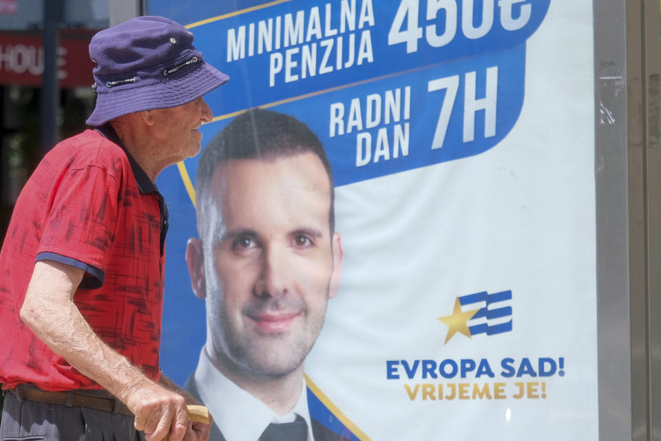 A man walks past a pre-election billboard showing leader of the Europe Now movement, financial expert Milojko Spajic in Podgorica, Montenegro, Friday, June 9, 2023. Montenegro is holding an early parliamentary election Sunday, a vote that could provide indications of whether the small NATO member in the Balkans will overcome the deep political divisions and instability that have hampered its route to joining the European Union. (AP Photo/Risto Bozovic)