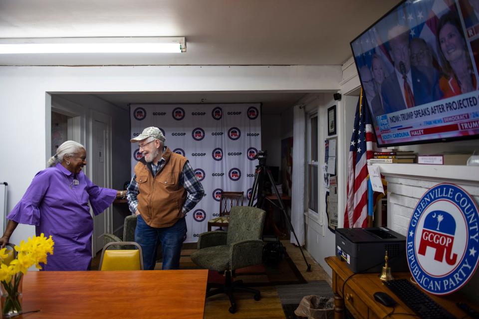 Yvonne Julian, Greenville County Republican Party chair, left, talks with Gregory Peck, 73, executive committeeman for Tubbs Mountain precinct, right, as they watch Donald Trump speak on the television during a watch party at the party headquarters in Greenville, S.C., on Saturday, Feb. 24, 2024.