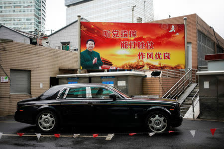 A poster with a portrait of Chinese President Xi Jinping overlooks a street in Shanghai, China, September 21, 2017. The slogan reads: "Follow the Party's command. Be capable of winning wars. Maintain good discipline." Picture taken September 21, 2017. REUTERS/Aly Song