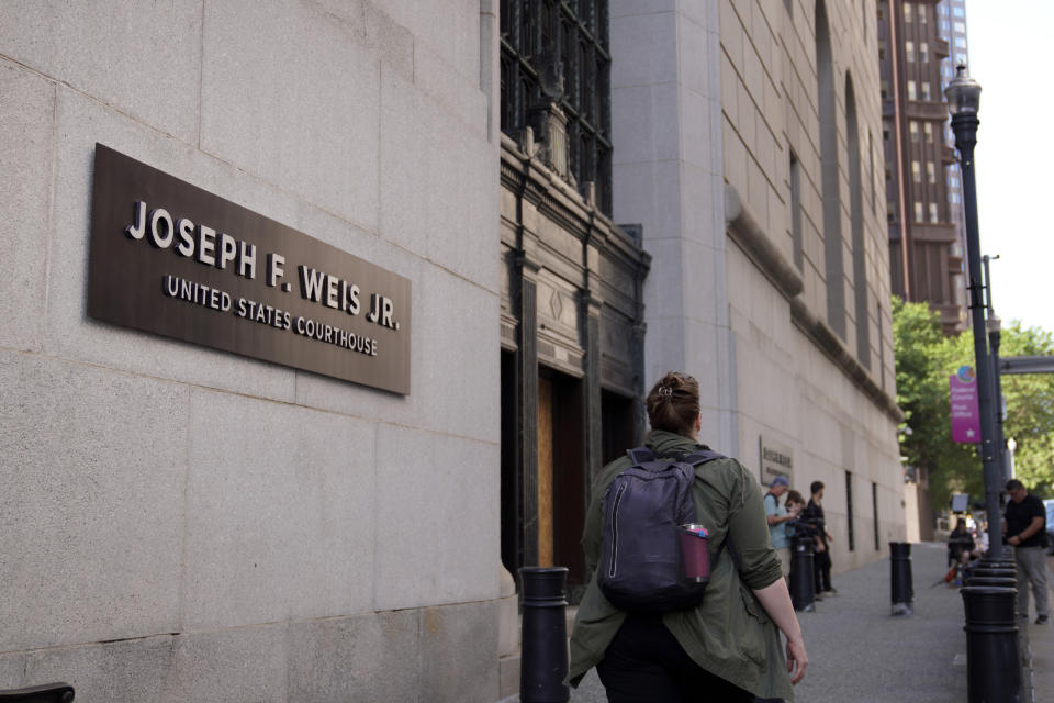 People walk by the Federal courthouse before the first day of trial for Robert Bowers, the suspect in the 2018 synagogue massacre on Tuesday, May 30, 2023, in Pittsburgh. Bowers could face the death penalty if convicted of some of the 63 counts he faces which claimed the lives of worshippers from three congregations who were sharing the building, Dor Hadash, New Light and Tree of Life.(AP Photo/Jessie Wardarski)