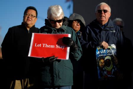 Demonstrators hold an "Interfaith Prayer Vigil for Immigrant Justice" outside the federal building, where ethnic Chinese Christians who fled Indonesia after wide scale rioting decades ago and overstayed their visas in the U.S. must check-in with ICE, in Manchester, New Hampshire, U.S., October 13, 2017. REUTERS/Brian Snyder