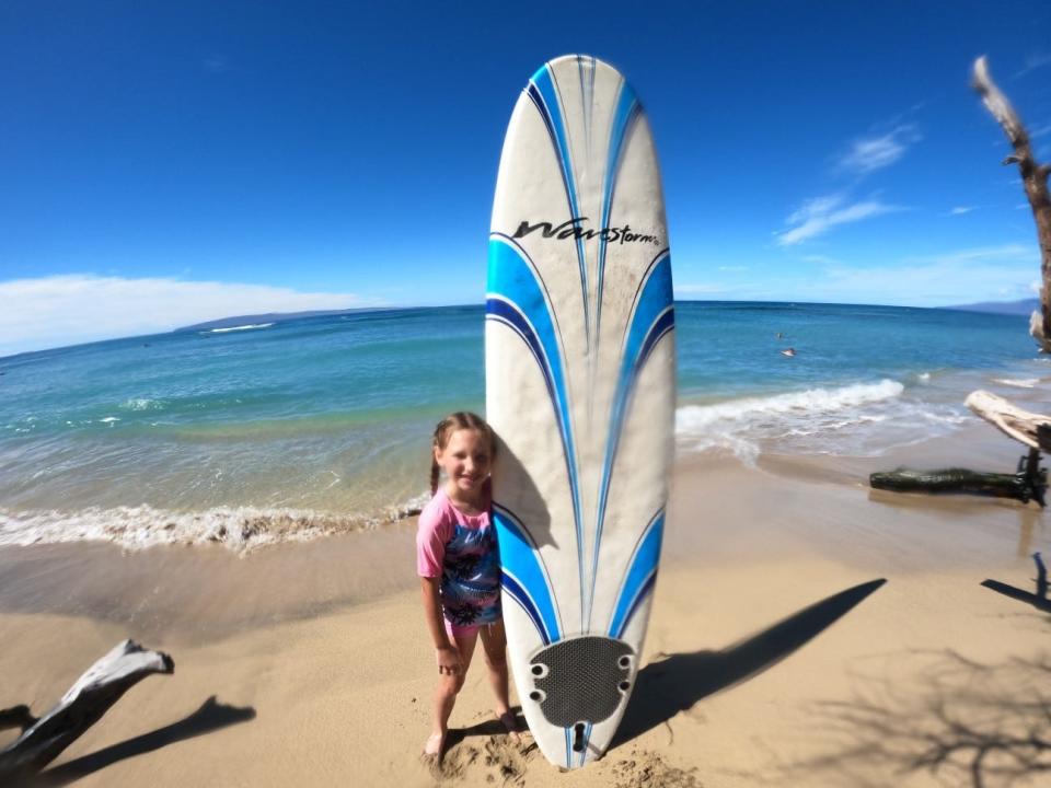 Laina Lessard, 8, took a surfing lesson at Ukumehame Beach on the Hawaiian island of Maui. She and her mother flew to Hawaii for a family wedding but almost didn't make it because she couldn't find a COVID test for Laina, who is unvaccinated.