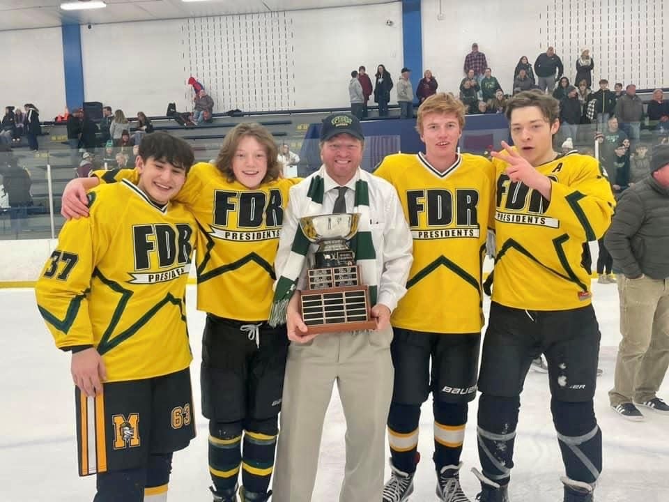 Franklin D. Roosevelt hockey coach Mark Maroney holds the championship trophy while flanked by teammates and Red Hook High School students Liam Maroney, Owen Maroney, Adam Jurkowski and Aiden Matera after winning the Hudson Valley High School Ice Hockey Association title on March 4, 2023.