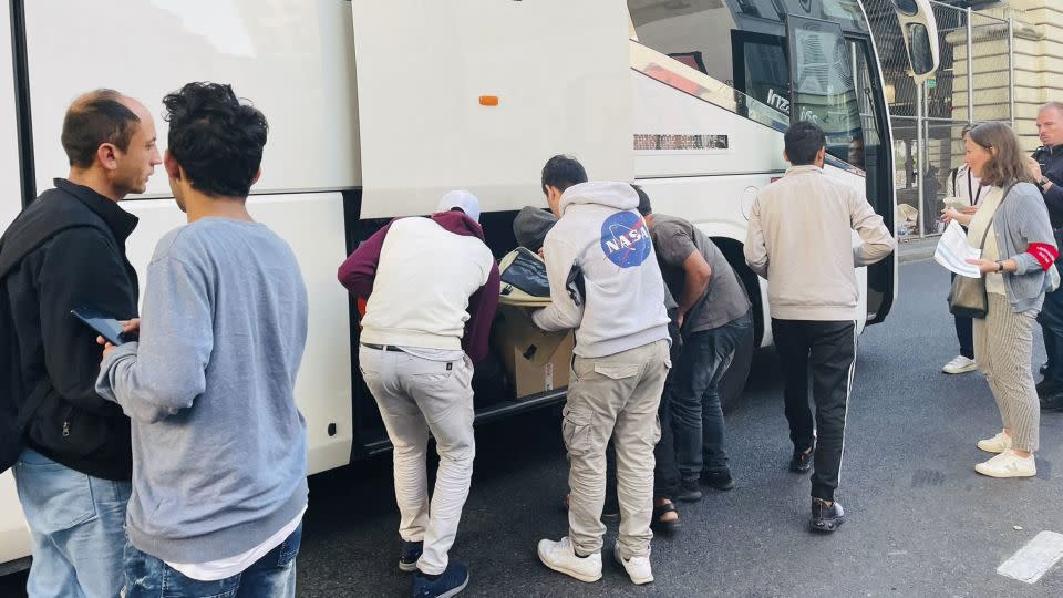 Homeless people load their belongings onto one of the buses in Paris. - Dalal Mawad/CNN