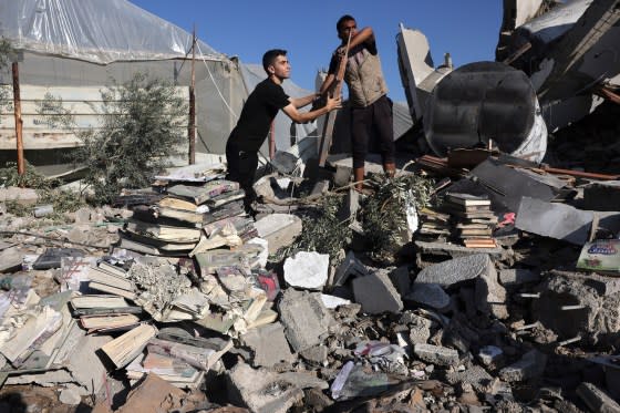 Palestinians collect books from the rubble of a cultural center following an Israeli strike in Rafah in the southern Gaza Strip on Nov.18. <span class="copyright">Mohammed Abed—AFP/Getty Images</span>