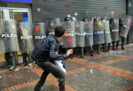 COLOMBIE, Bogota. Un étudiant lance des bombes de peinture contre la police lors d'une manifestation pour réclamer un meilleur système éducatif et une nouvelle réforme de l'université, le 21 mars 2013. AFP/Guillermo Legaria
