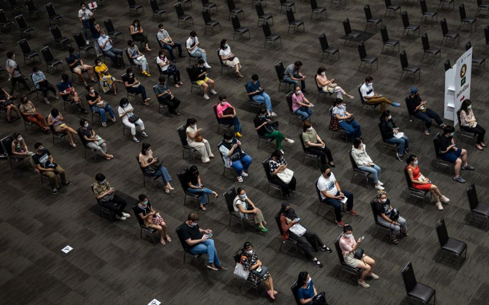 People are seen taking seats while waiting to get administered the AstraZeneca Covid-19 coronavirus vaccine - Sirachai Arunrugstichai/Getty