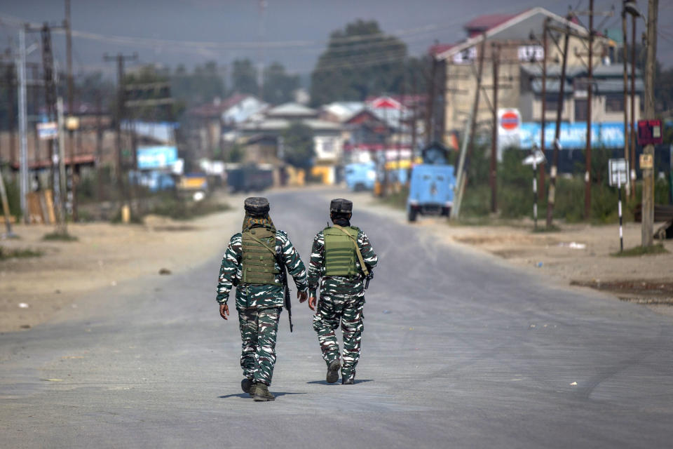 Indian paramilitary soldiers patrols on a road leading towards the site of a gunfight in Pampore, south of Srinagar, Indian controlled Kashmir, Saturday, Oct. 16, 2021. Indian government forces killed five rebels in last 24-hours in disputed Kashmir on Saturday, officials said, as violence increased in recent weeks.(AP Photo/Dar Yasin)