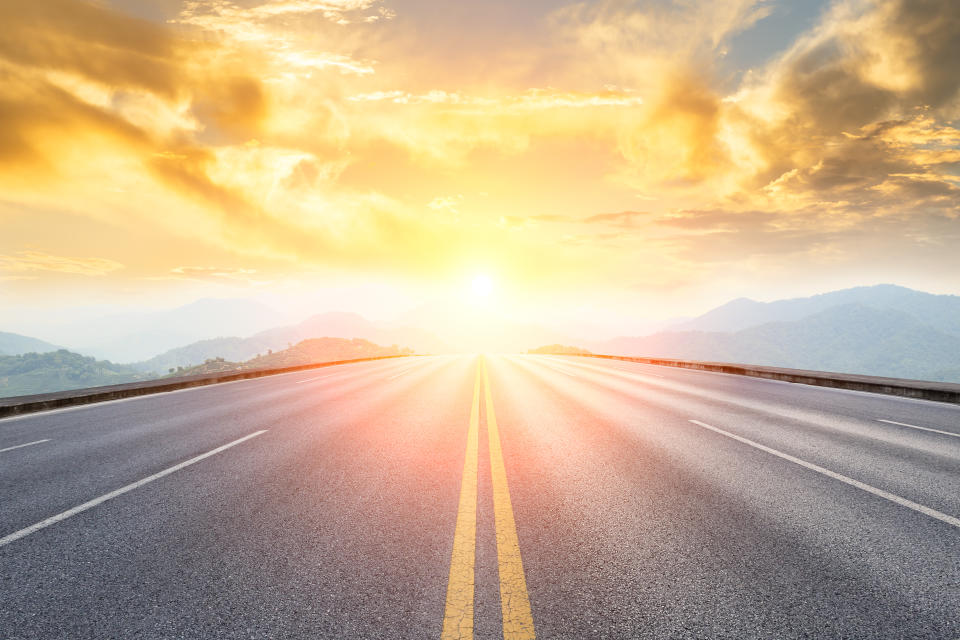 asphalt road and mountains with foggy nature landscape at sunset