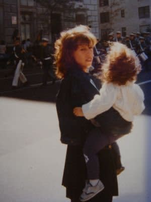 My mom carrying me at a parade in NYC, around 1985