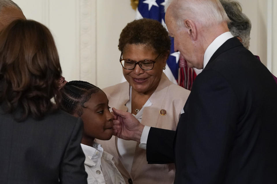FILE - President Joe Biden greets Gianna Floyd, the daughter of George Floyd, after he signed an executive order in the East Room of the White House, May 25, 2022, in Washington. The order comes on the second anniversary of George Floyd's death, and is focused on policing. Watching are Vice President Kamala Harris and Rep. Karen Bass, D-Calif. The third anniversary of Floyd’s murder is Thursday, May 25, 2023. (AP Photo/Alex Brandon, File)