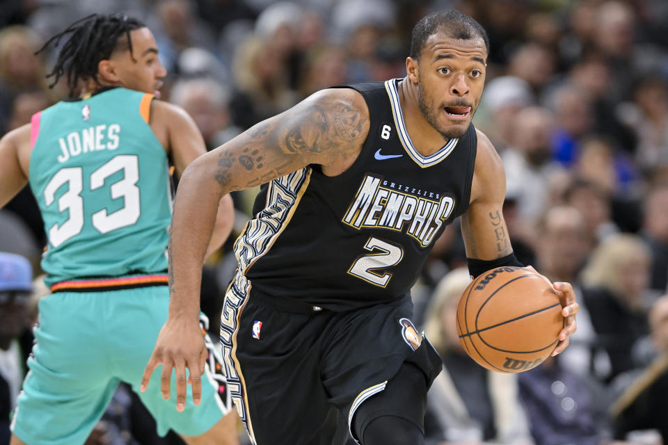 Memphis Grizzlies' Xavier Tillman Sr. (2) drives past San Antonio Spurs' Tre Jones during the second half of an NBA basketball game, Friday, March 17, 2023, in San Antonio. (AP Photo/Darren Abate)