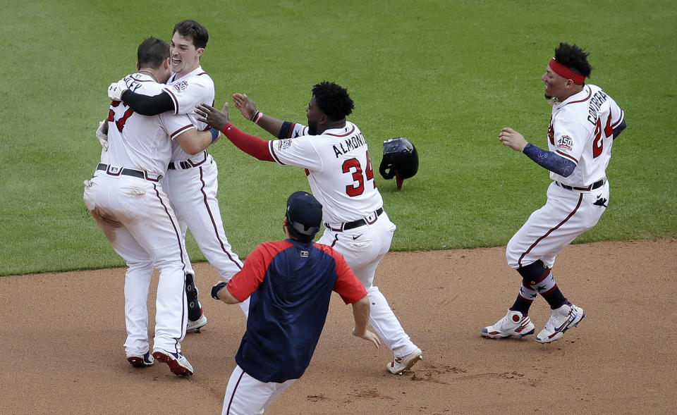 Atlanta Braves' Max Fried, second from left, is mobbed after making the game winning hit against the Miami Marlins during the tenth inning of a baseball game Sunday, July 4, 2021, in Atlanta. (AP Photo/Ben Margot)