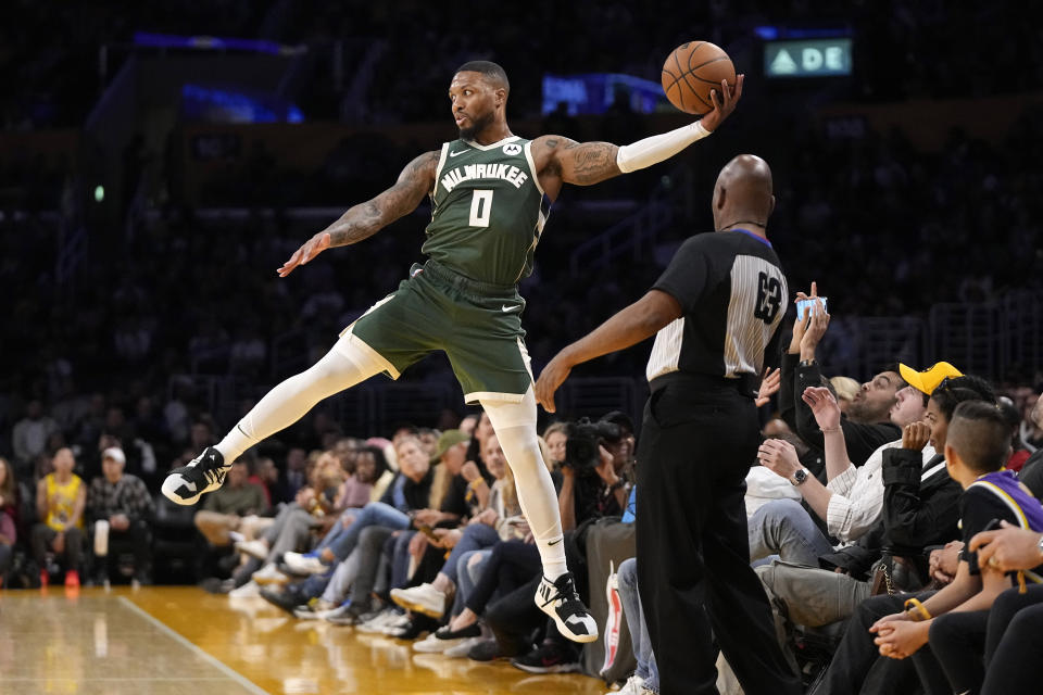Milwaukee Bucks forward MarJon Beauchamp jumps to keep a ball inbounds as referee Derek Richardson watches during the first half of an NBA preseason basketball game against the Los Angeles Lakers Sunday, Oct. 15, 2023, in Los Angeles. (AP Photo/Mark J. Terrill)