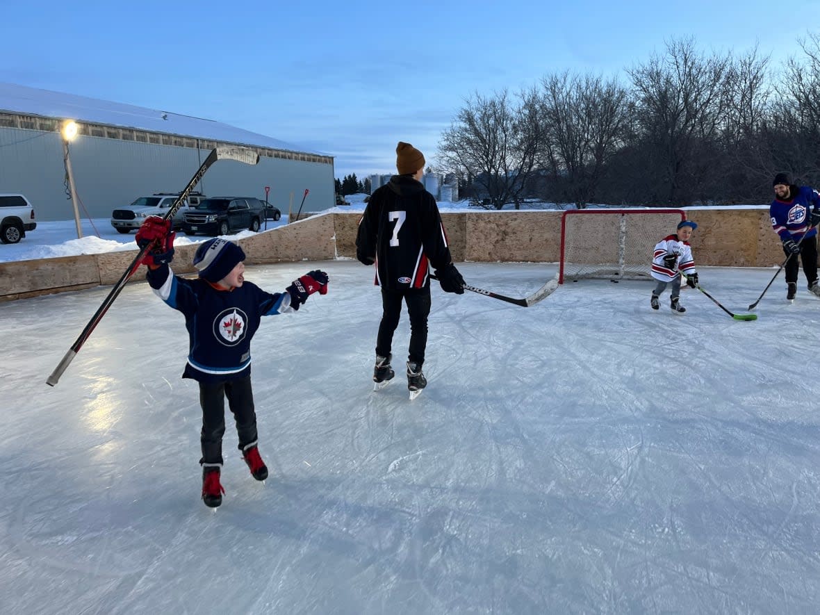 Liam Wiebe celebrates a goal against his cousins during a hockey game that's a family affair on the Wiebe farm near MacGregor, Man. (Cameron MacIntosh/CBC News - image credit)