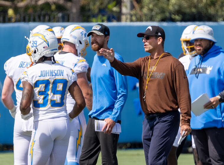 Coach Jim Harbaugh (brown hoodie) is pointing the Chargers in a new direction.