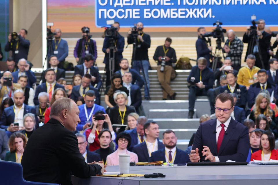 Questions from the Russian public come through on a large blue screen in front of Putin (POOL/AFP via Getty Images)