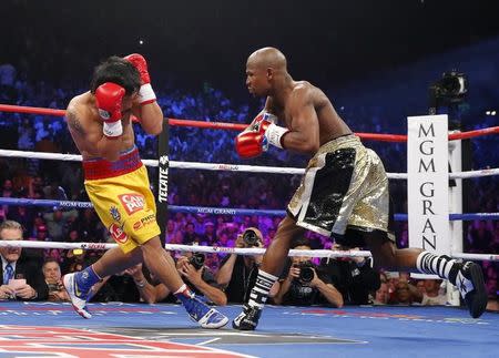 Floyd Mayweather, Jr. of the U.S. goes after Manny Pacquiao of the Philippines (L) in the first round during their welterweight WBO, WBC and WBA (Super) title fight in Las Vegas, Nevada, May 2, 2015. REUTERS/Steve Marcus