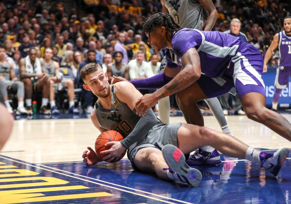 West Virginia's Erik Stevenson (10) and Kansas State's Tykei Greene battle for a loose ball during Saturday's game in Morgantown, W.Va.