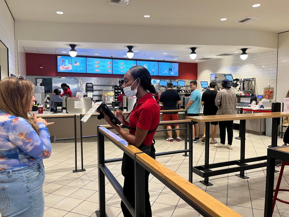chick fil a employee taking a customer's order through a tablet at a toronto chick fil a