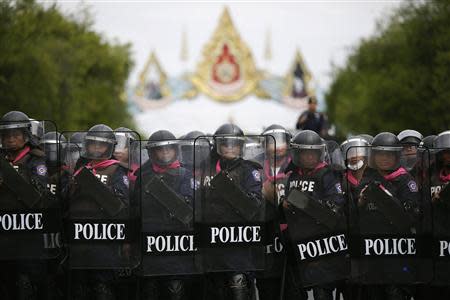 Policemen take position to stop protesters against an amnesty bill marching on the main road near the government and parliament buildings in central Bangkok November 7, 2013. REUTERS/Damir Sagolj