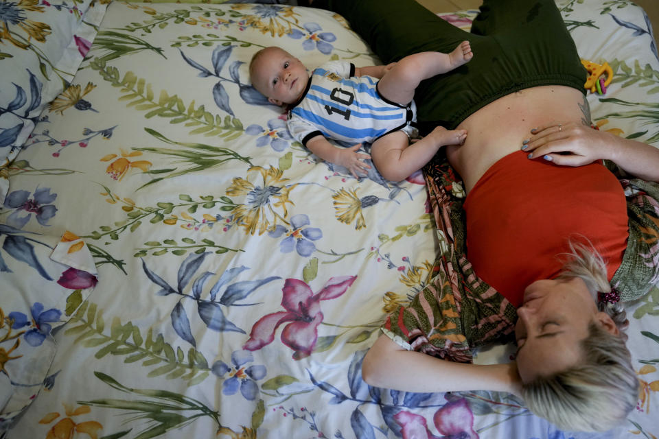 Russian national Alla Prigolovkina lies on a bed with her Argentine-born son Lev Andres, at their home in Mendoza, Argentina, Tuesday, Feb. 14, 2023. According to official figures, some 22,200 Russians entered Argentina over the last year, including 10,777 women—many of whom were in the advanced stages of pregnancy. (AP Photo/Natacha Pisarenko)