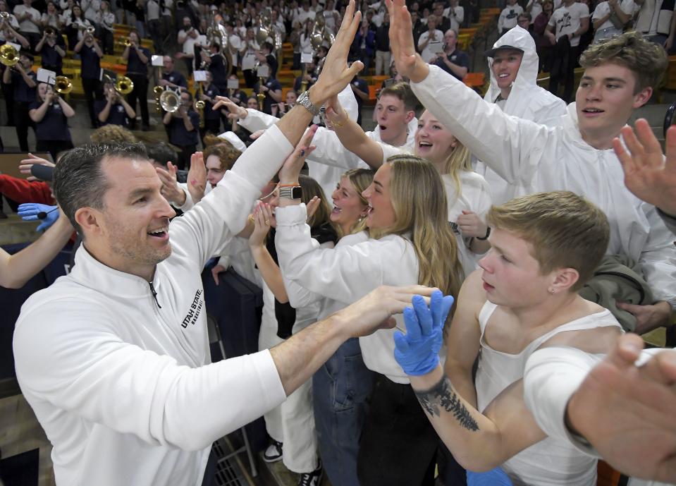 Utah State coach Danny Sprinkle, left, celebrates with students after defeating San Jose State Tuesday, Jan. 30, 2024, in Logan, Utah. The first-year Aggies coach has USU flying high in Logan. | Eli Lucero/The Herald Journal via Associated Press