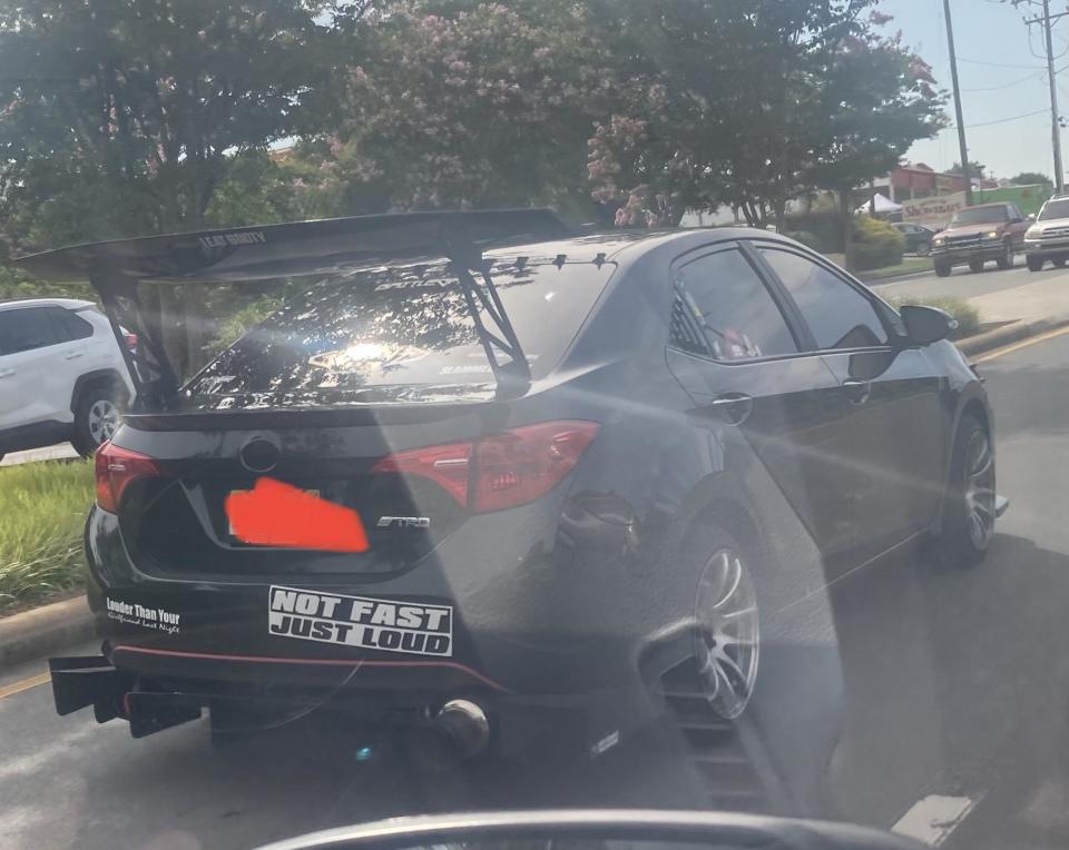 A Toyota car with a bumper sticker that says "Not fast just loud"